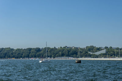 Sailboats in sea against clear sky
