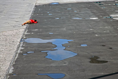 Rear view of boy lying down on street