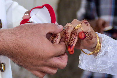 Cropped hand of man putting ring during wedding ceremony