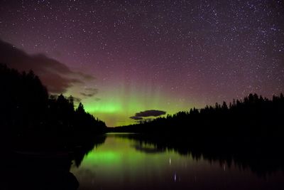 Scenic view of lake against sky at night