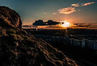 Sunset from above city reflecting on cliff edge