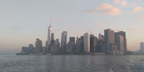 Sea by buildings against sky in city