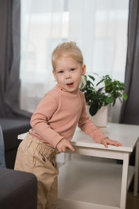 Portrait of cute girl sitting on sofa at home