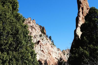 Low angle view of rocks against blue sky