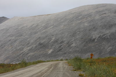 Road leading towards mountain against sky