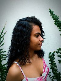 Young woman standing against wall