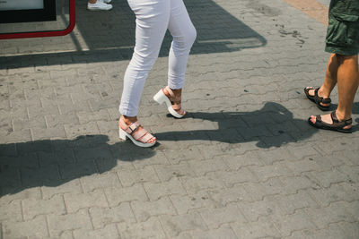 Low section of people standing on footpath