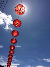 Low angle view of paper lantern hanging against sky on sunny day