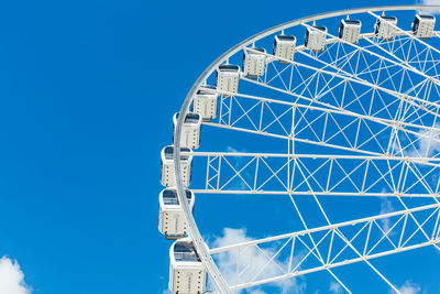 Low angle view of ferris wheel against blue sky