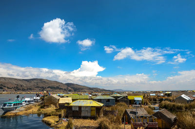 Houses by mountains against blue sky