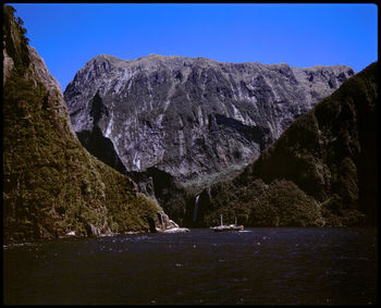 Scenic view of sea and mountains against clear sky