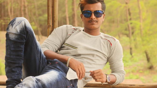Portrait of teenage boy sitting on sunglasses