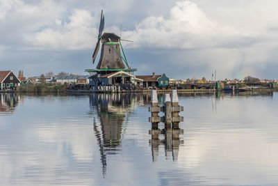 Traditional windmill in water against sky