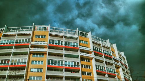 Low angle view of buildings against cloudy sky at dusk