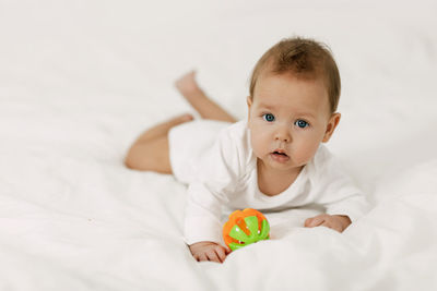 Portrait of cute baby lying on bed