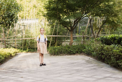 Back to school. little girl with yellow backpack from elementary school outdoor
