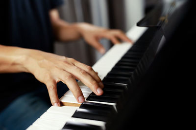 Midsection of man playing piano