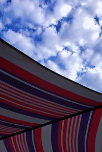 Low angle view of flags against cloudy sky