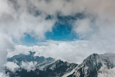 Low angle view of snowcapped mountains against sky