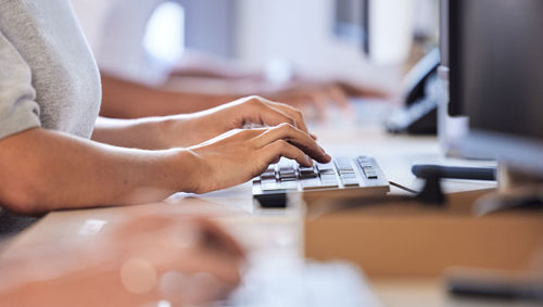 Midsection of man using laptop on table