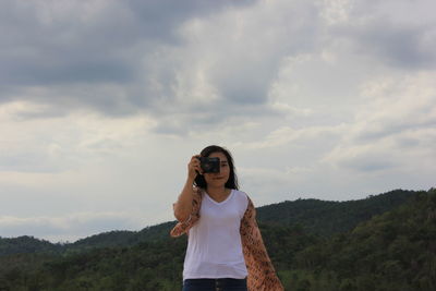 Full length of woman standing against sky