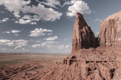 Scenic view of rock formations and landscape against cloudy sky