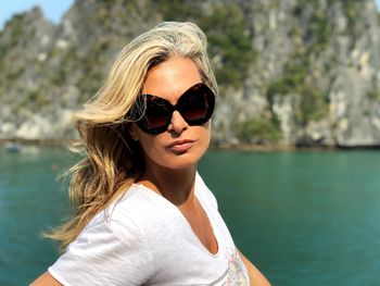 Portrait of woman wearing sunglasses against sea