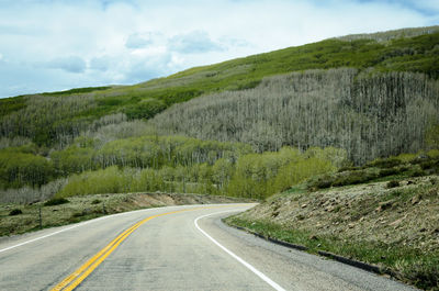 Road leading towards mountains against sky