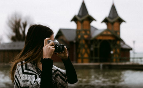 Portrait of woman photographing through camera