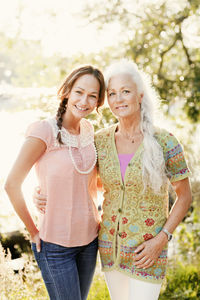 Portrait of adult daughter and mother in garden