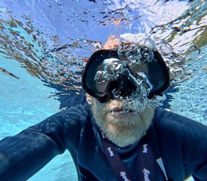 Portrait of young man swimming in sea