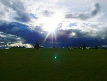 Scenic view of grassy field against cloudy sky