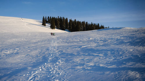 People skiing on snowcapped mountain against sky