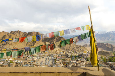 Multi colored flags hanging on mountain against sky