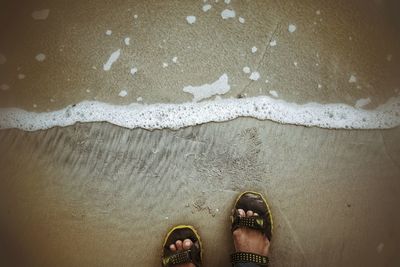 Low section of man standing by water