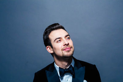 Portrait of young man against blue background