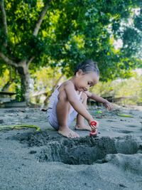 Full length of boy playing on tree