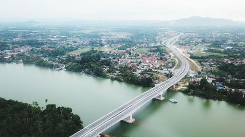 High angle view of river amidst city against sky