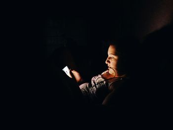 Midsection of man using mobile phone in darkroom