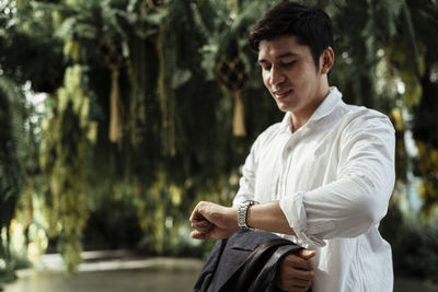 Full length of young man standing against trees