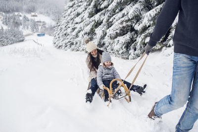 Happy family with sledge in winter landscape