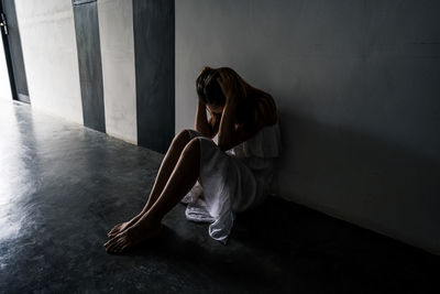 Young woman sitting on floor at home