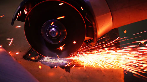Close-up of sparks emitting from electric saw in factory