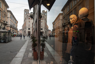 People walking on street amidst buildings in city