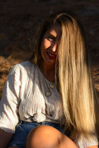 Portrait of smiling woman sitting outdoors