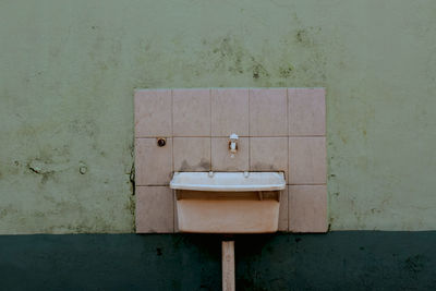 Old sink on wall in bathroom