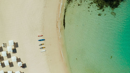 Tropical sandy beach with sun beds near the lagoon with turquoise water from above, boracay