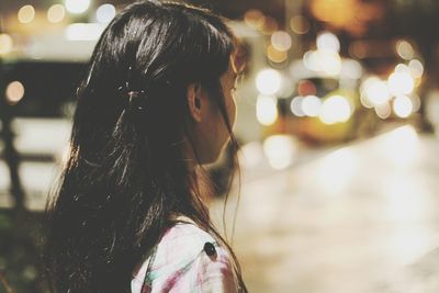 Rear view of girl with illuminated hair at night