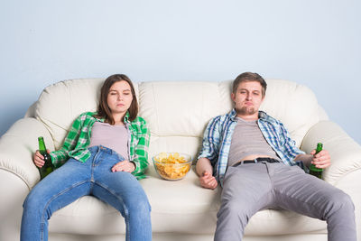 Full length of man sitting on sofa