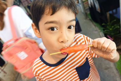 Close-up portrait of boy eating flavored ice candy